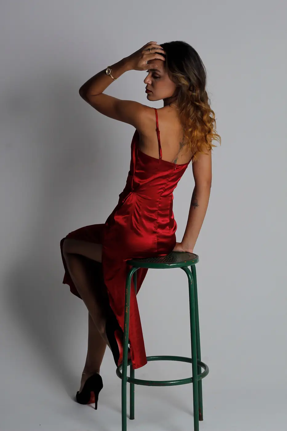 Modelo de vestido vermelho num banco de estúdio
