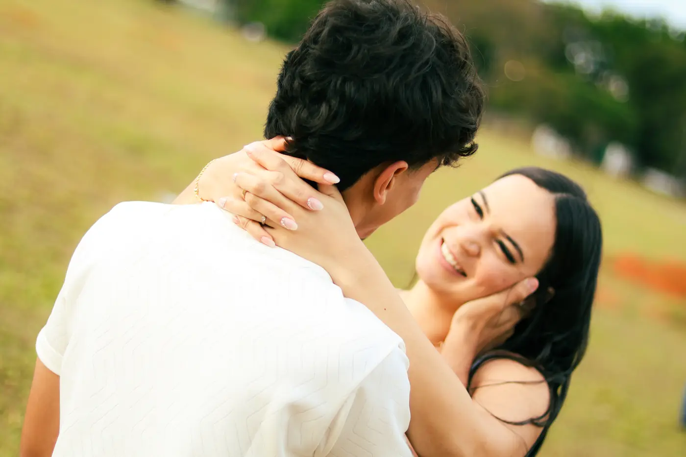 Casal abraçado num gramado