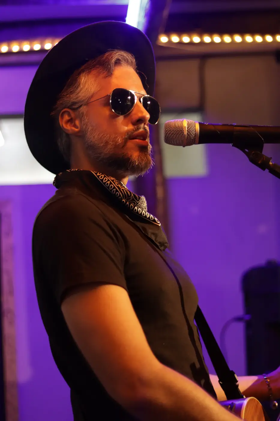 Cantor no palco com chapéu e óculos escuros